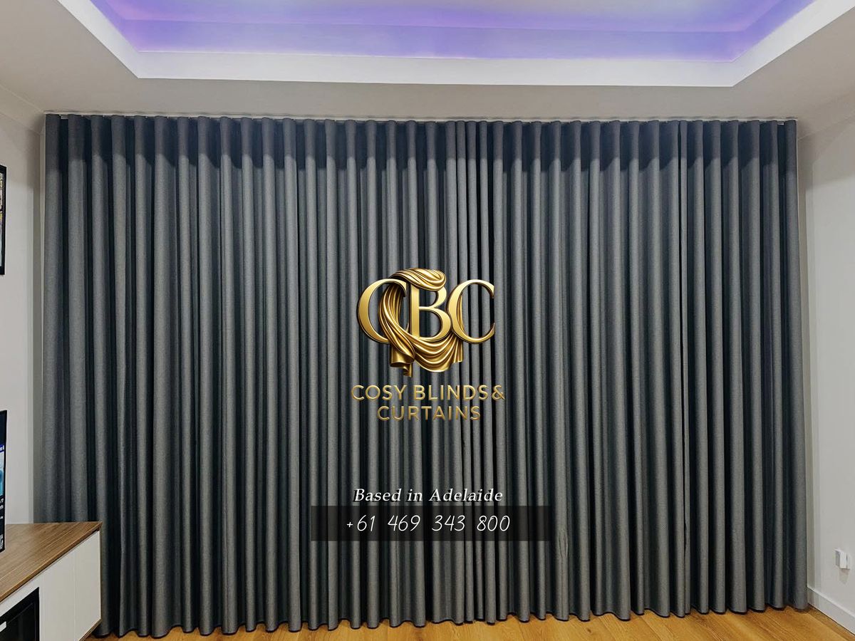 Charcoal wave-fold drapes under an LED ceiling
